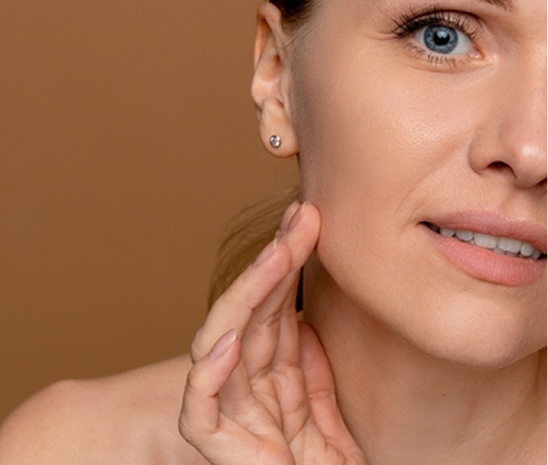 Woman touching jawline representing cyst removal treatment